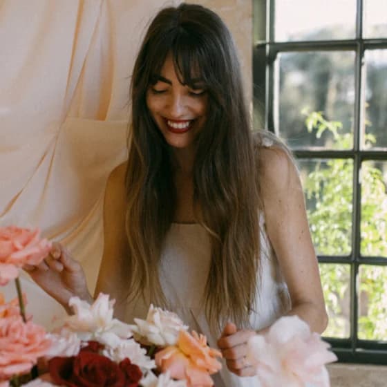 Anja of Bloeme, building an arrangement of blush and burgundy roses