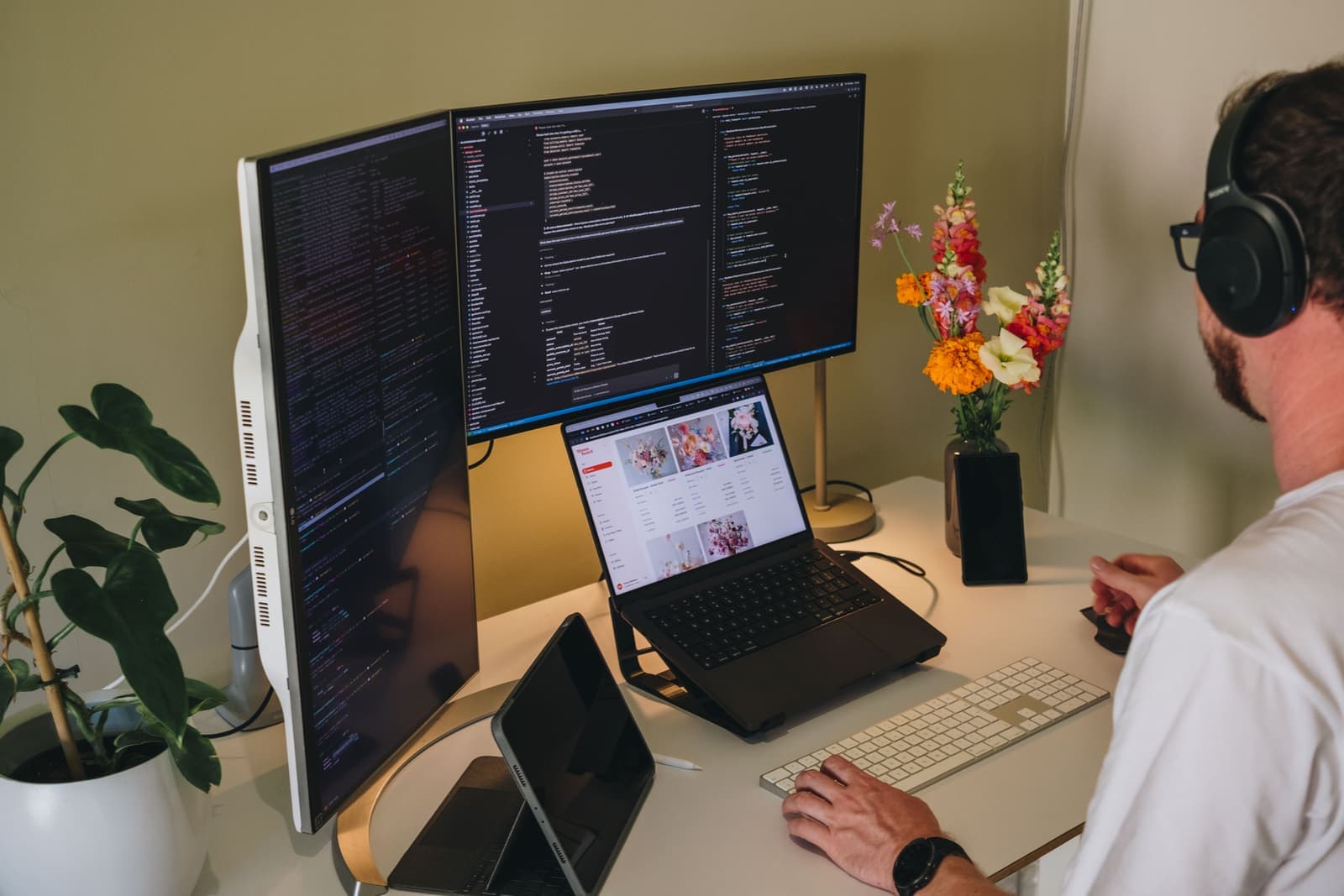 Dylan building BloomBoard — code on the monitors, BloomBoard on the laptop