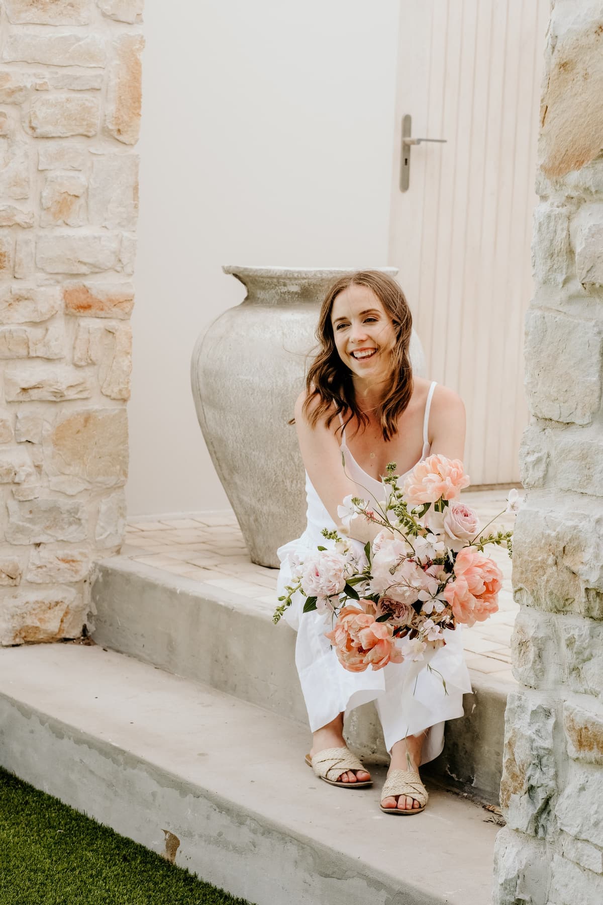 Pippa holding a peach and blush bouquet