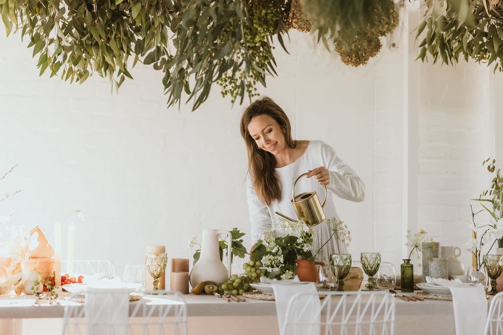 Pippa dressing a long table in the studio