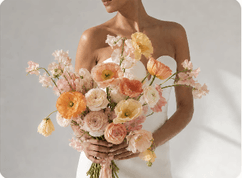 Bride holding a loose coral and cream bouquet